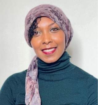 Portrait photo of a young woman in a headscarf smiling to camera.