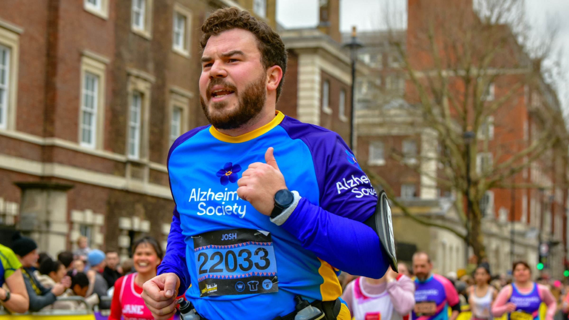 Alzheimer's Society runner taking part in a race in a city area