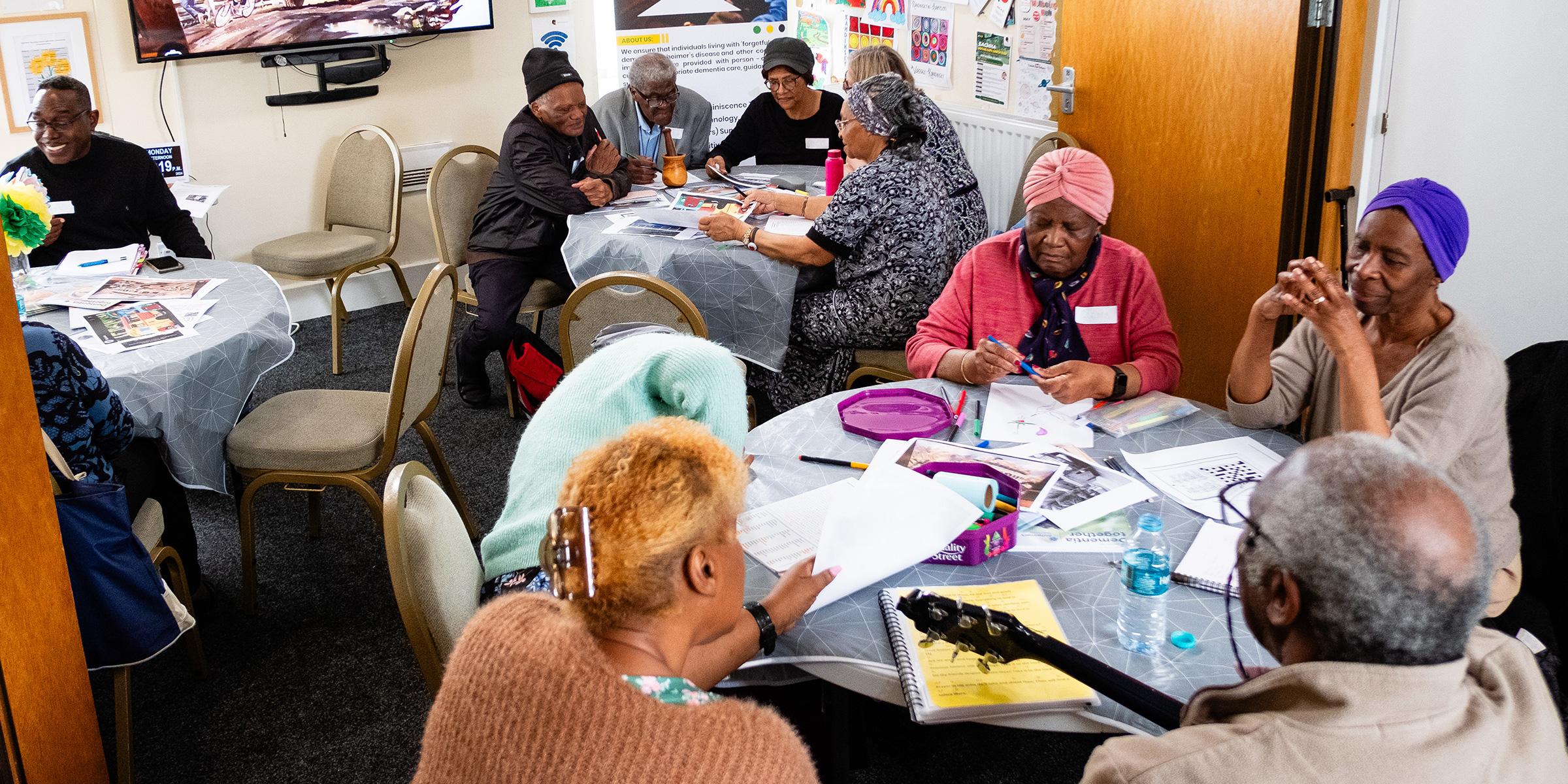 Members of Sheffield Memory Hub sat down at tables talking and looking at objects