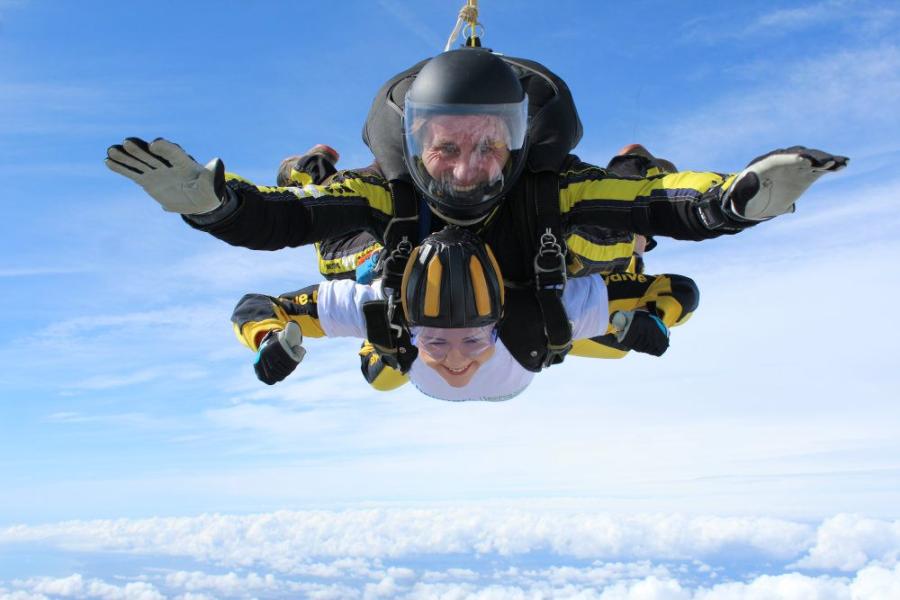 Woman skydiving above the clouds