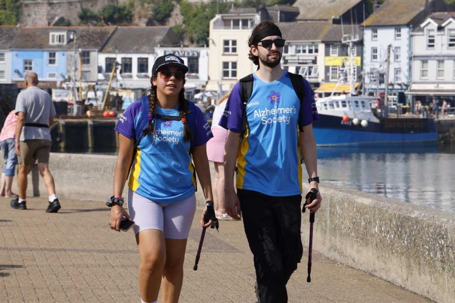 Two people trekking by some docks