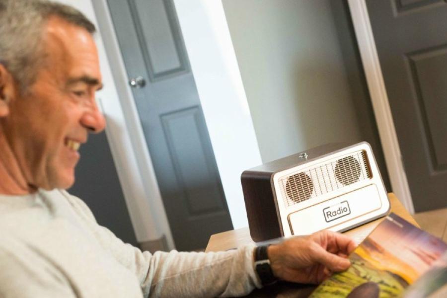 Man reading a magazine next to his one button radio