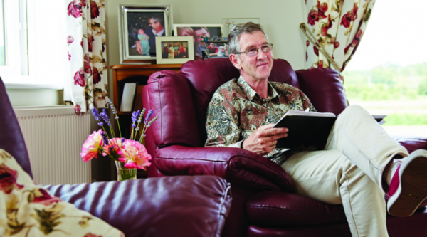 A man sitting on a leather chair reading a book