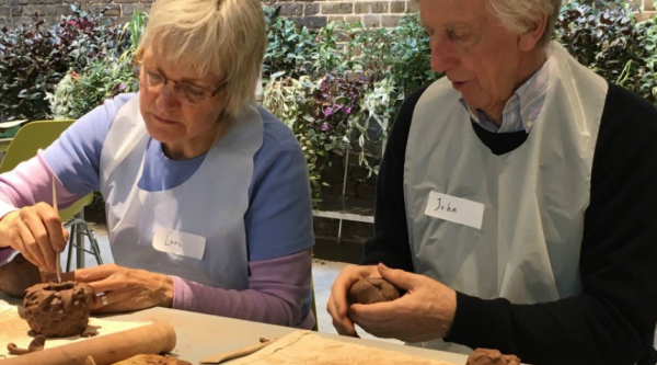 John and Lori sitting down and making pottery 