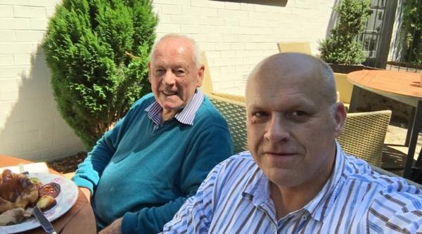 Andy and his dad enjoying food in the sunshine