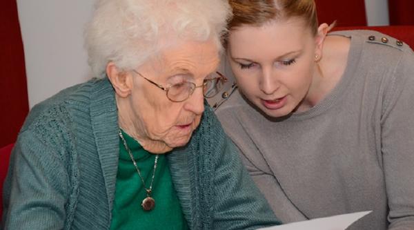 A woman reading with an older woman
