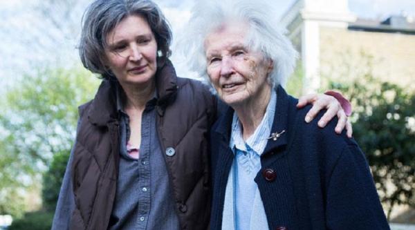 A woman supporting another woman whilst walking