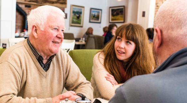 Three people having a conversation in a cafe