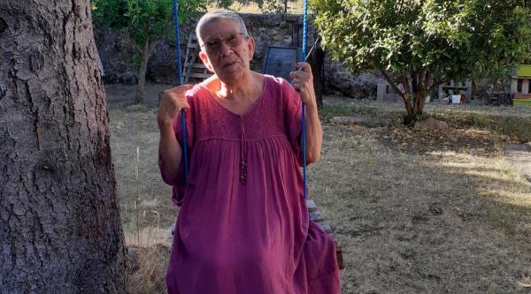 Lucas' grandma sitting on a swing below a tree
