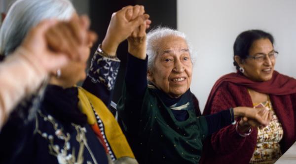 Bhagwant and some of the women from her community group, holding hands and singing