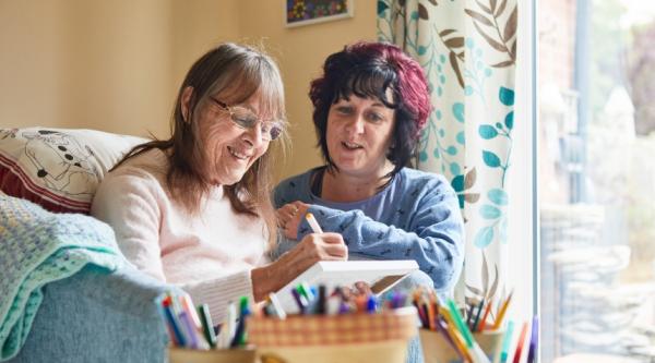 Two women doing an activity with coloured pens