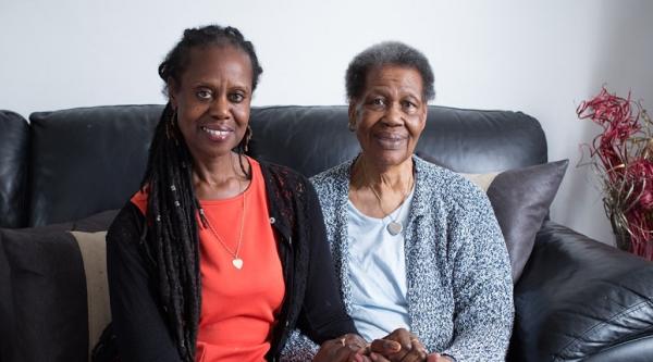 Enomwoyi sitting on the sofa with her mum, Pearl