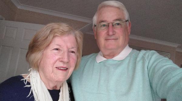 John and his partner smiling together indoors
