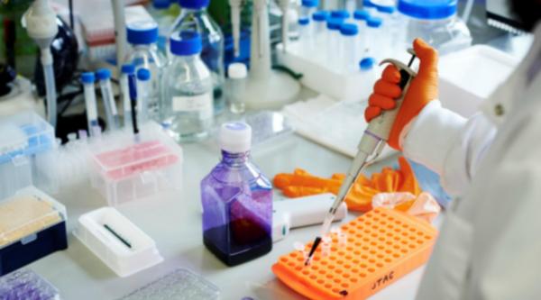 Person in lab working with a pipette