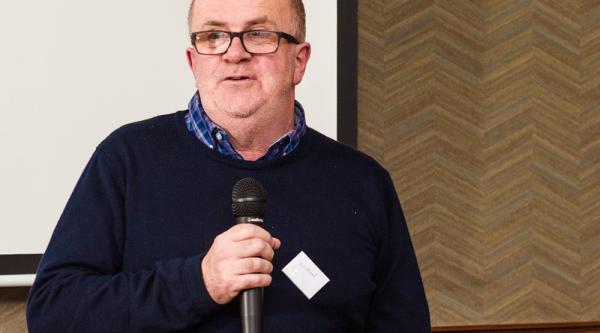 A man with dementia presenting on a microphone