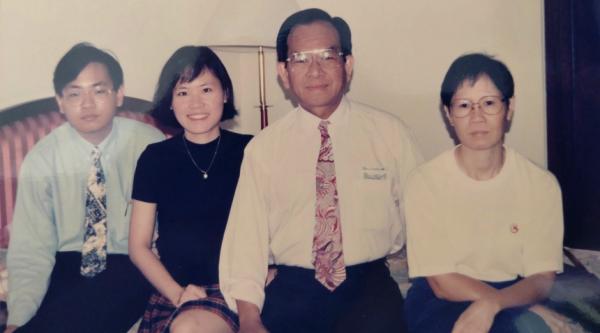 Ai Lyn, her brother and her parents sit on the sofa together