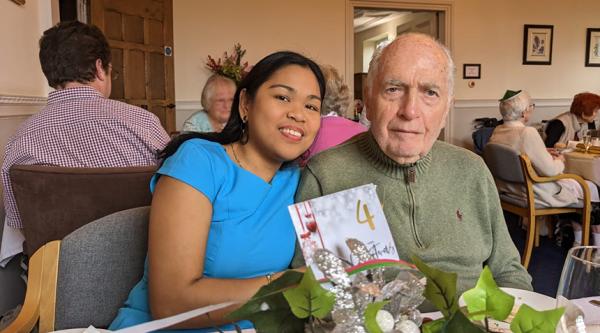 Daisy and Roy Timms sit together in a restaurant, they are both looking at the camera