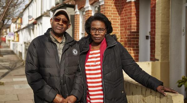 A couple standing outside their house