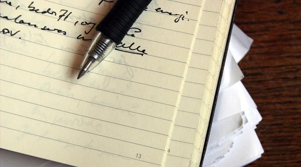 Pen, notebook and papers on a desk