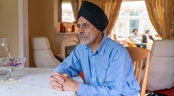Dalwinder sat at a dining table, staring into the distance