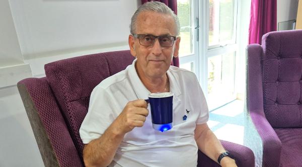 Man holding up Droplet Reminder mug