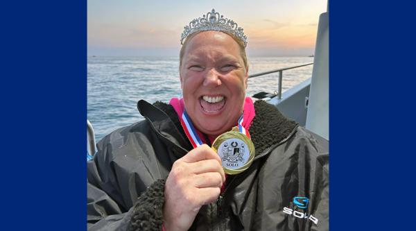 Lindsey stood on a boat, wearing a medal and tiara