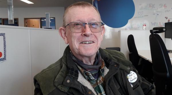 An almost bald man with glasses smiling