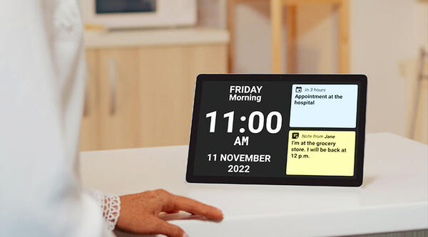 Electronic screen showing time and date, and two daily reminders. 