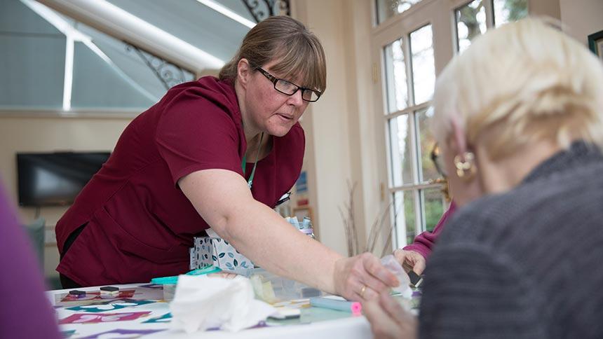 A staff member at St Teresa's Hospice supporting a woman