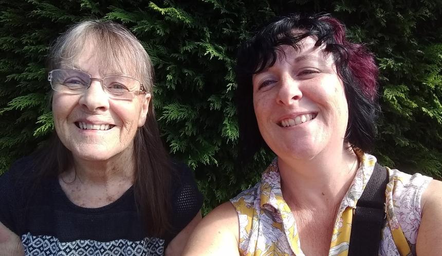 Louise and Marion smiling wearing summer clothes outside in the sunshine