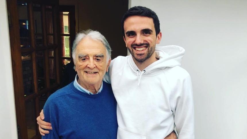 Charlie with his arm round his grandad. Both of them are smiling.