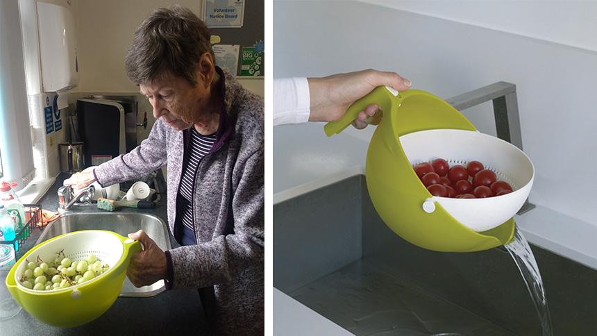 Woman in purple top next to a sink washes grapes in colander and water is poured from the colander into a sinkd 