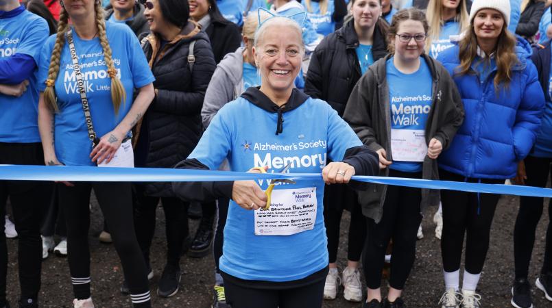 Memory Walk participant poised at the start line ready to cut the ribbon and open the walk