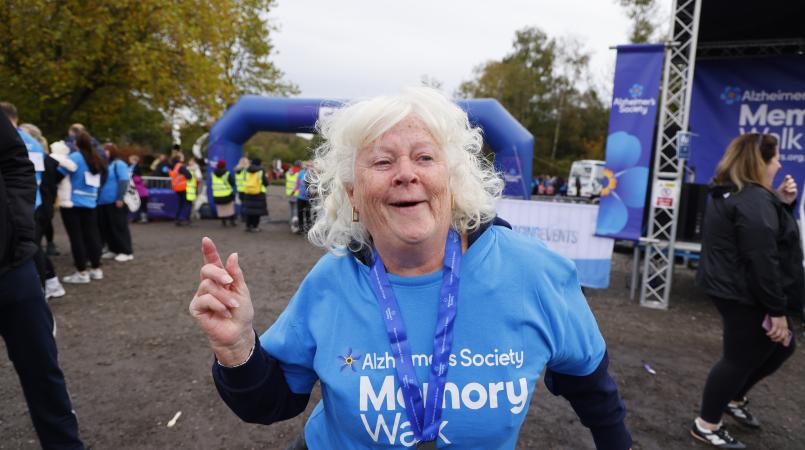 Extremely happy lady proudly wearing her medal after completing the Manchester Memory Walk