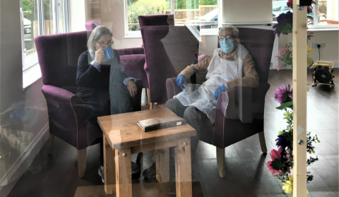 Tony Ward, wearing full PPE, sitting beside his wife, Sheila
