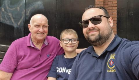 Keith Day smiling beside two members of his family
