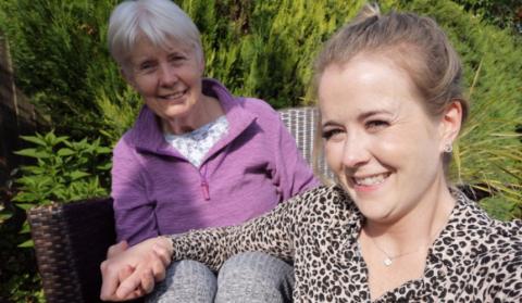 Lara and her mum, Sandee, in the garden holding hands and smiling in a selfie