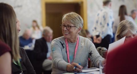 A woman who works for the Society speaking with supporters at an event