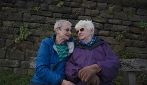 Hilary and Pauline sitting closely together outside