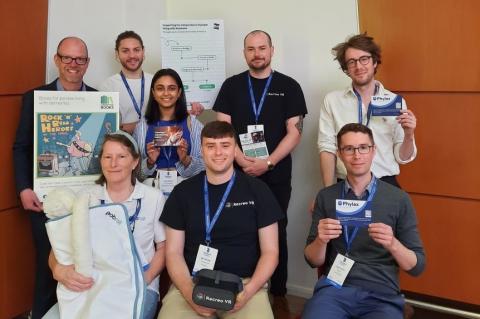 A group of dementia innovators stand in front of a board