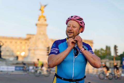 Man adjusting cycle helmet in sunshine