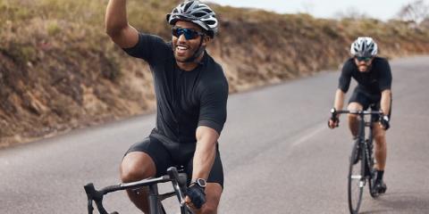 Two men cycling on an open road.