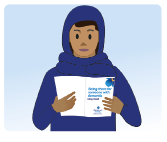 A person wearing blue reads an Alzheimer's Society booklet