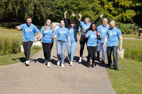 Group pf people wearing blue Memory Walk t-shirts, smiling with their arms in the air