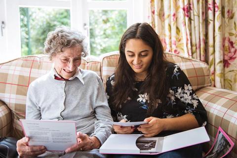 Two people seated indoors looking at a magazine